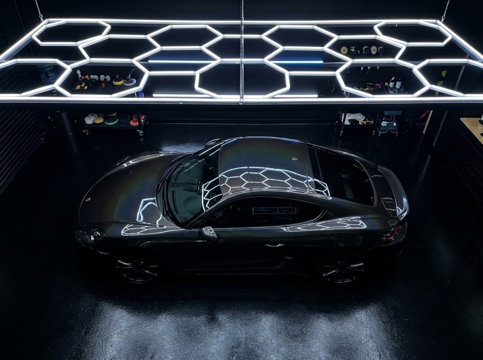 Mirror-black supercar under hexagonal studio lights